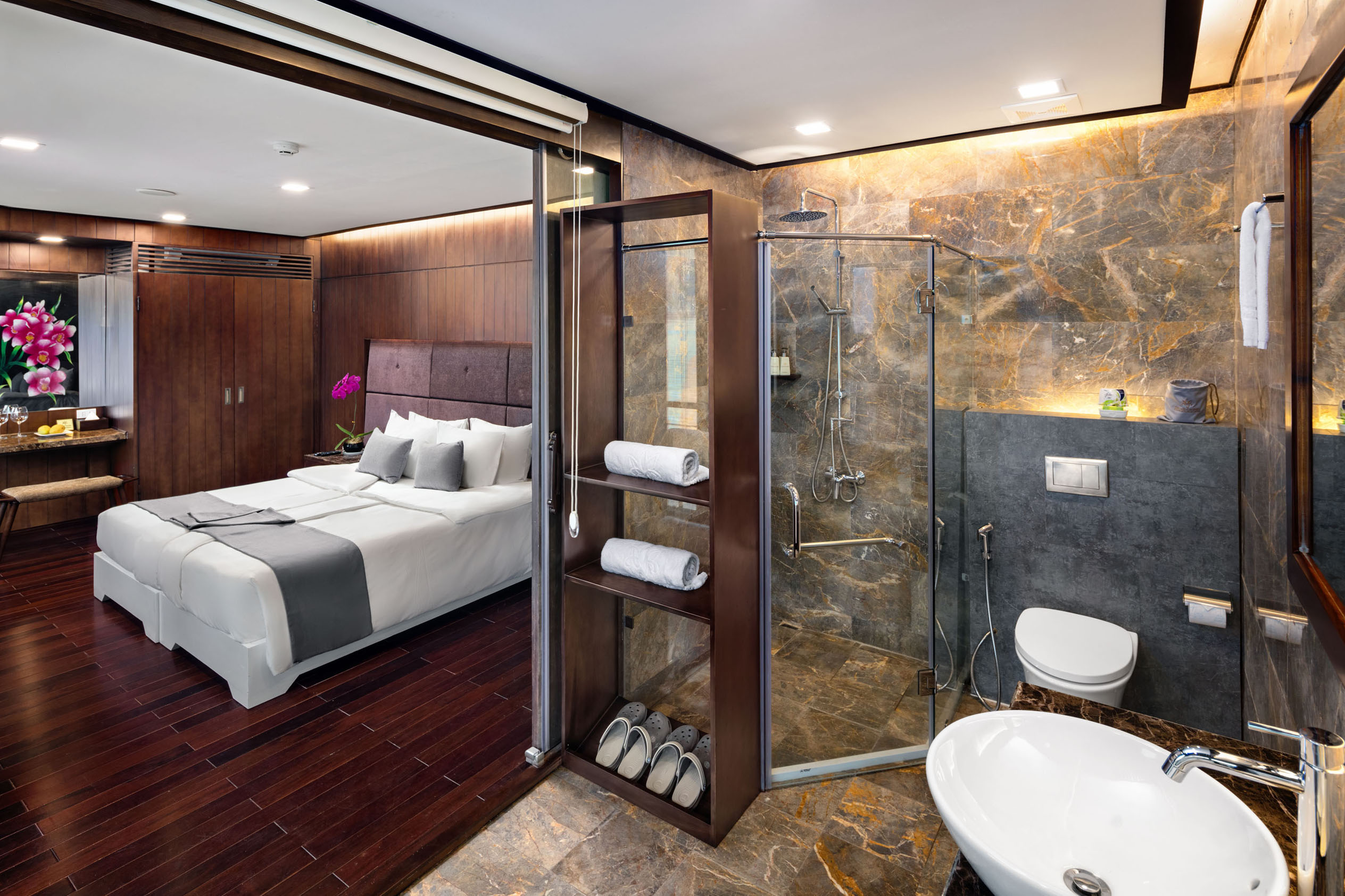 Luxurious hotel bedroom with modern ensuite bathroom, wooden accents, and elegant decor.