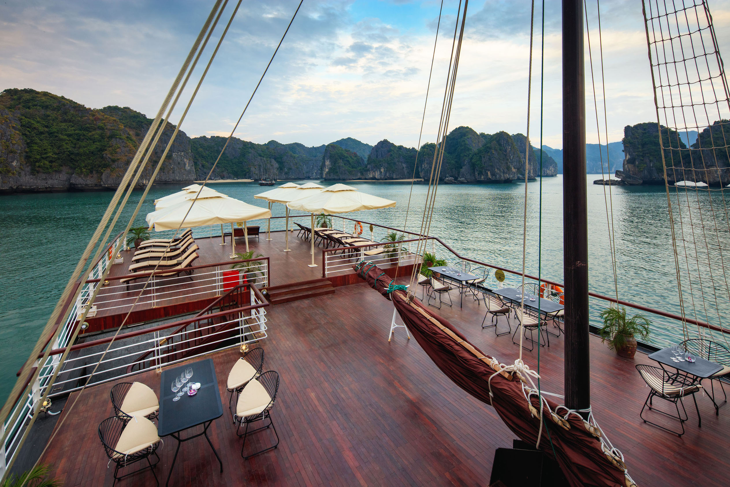 Luxurious cruise ship deck with panoramic views of limestone islands and clear waters in Vietnam.