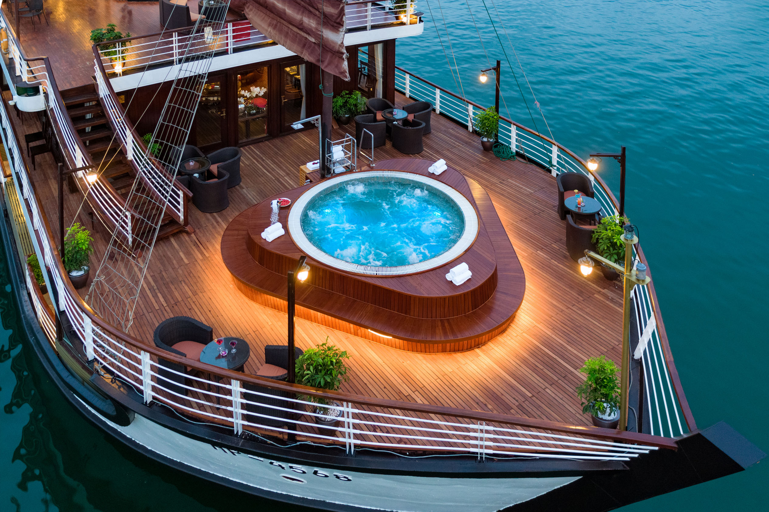 Luxurious yacht deck with private hot tub and outdoor seating, perfect for exclusive cruise experiences.