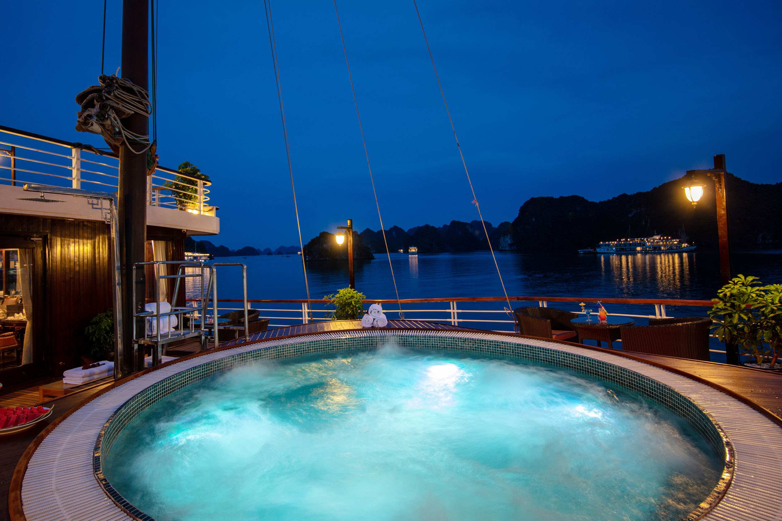 Relaxing night view of a luxury cruise ship hot tub overlooking Halong Bay in Vietnam.