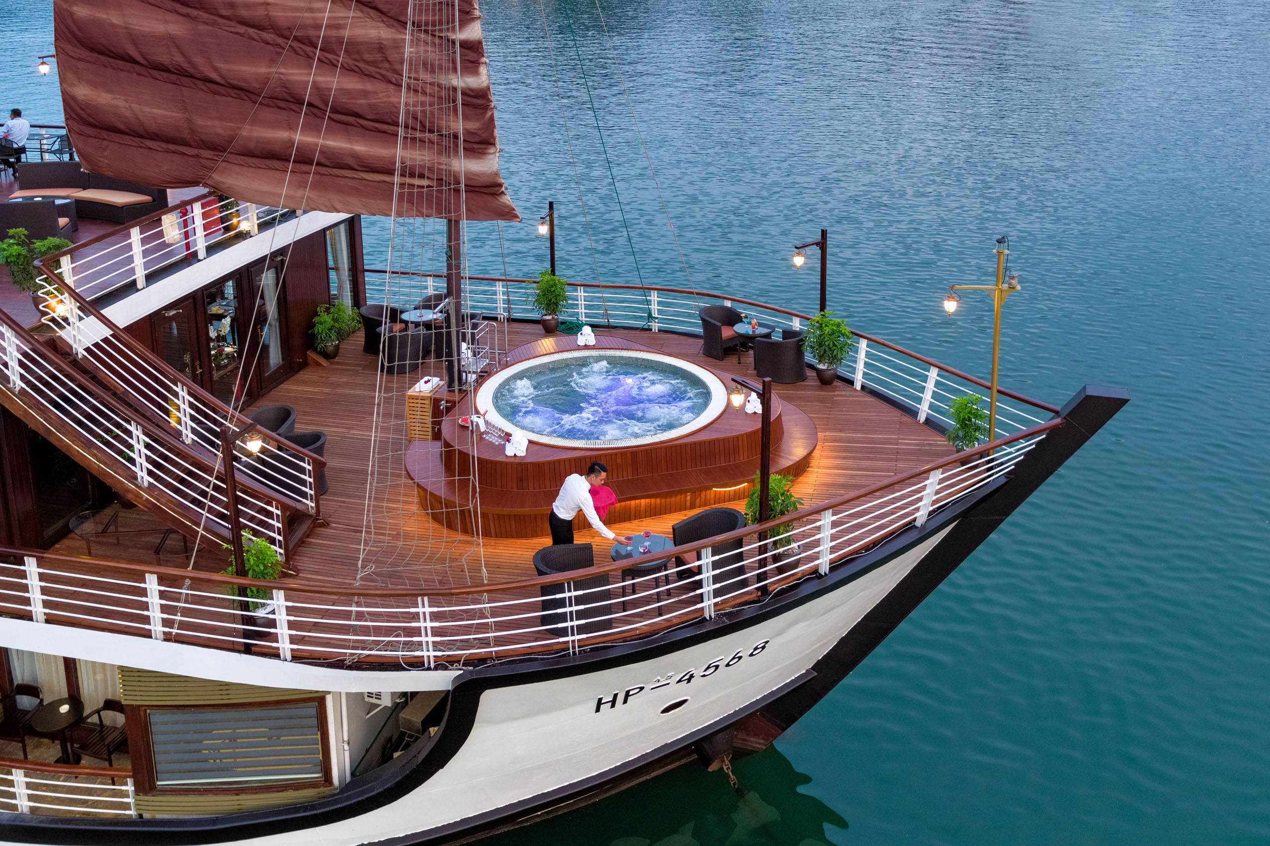 Luxurious cruise ship deck with hot tub and seaside dining, perfect for Vietnam island tours.
