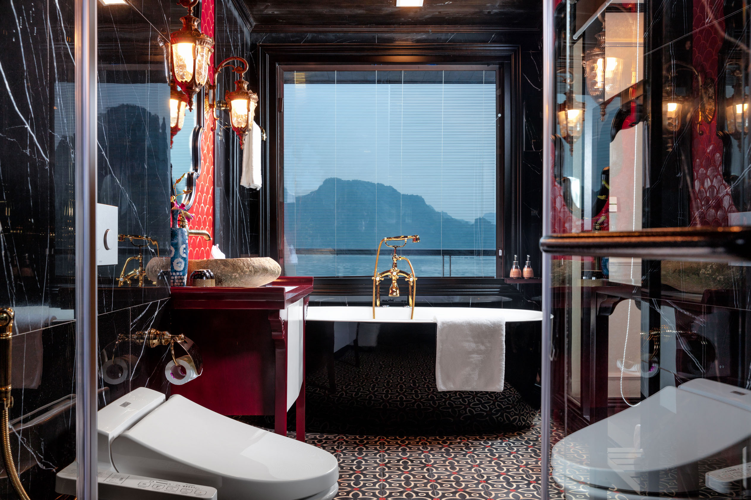 Luxurious bathroom with mountain view, black marble walls, gold fixtures, elegant decor, perfect for Vietnam luxury travel.