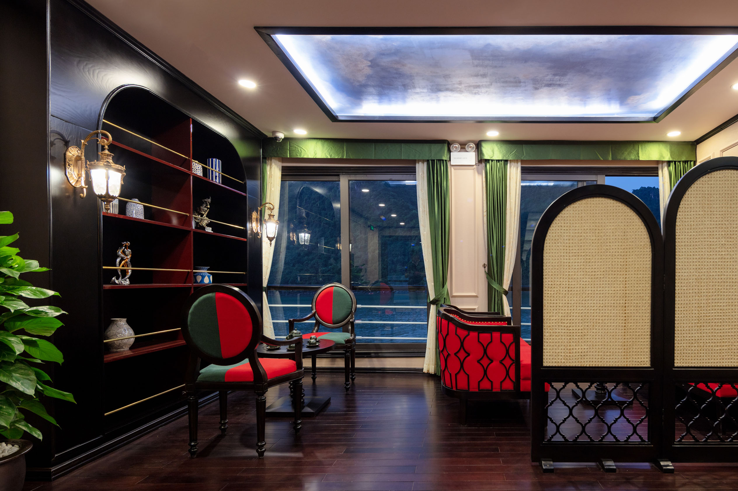 Elegant hotel lounge with classic furniture, wooden flooring, and scenic mountain views through large windows.