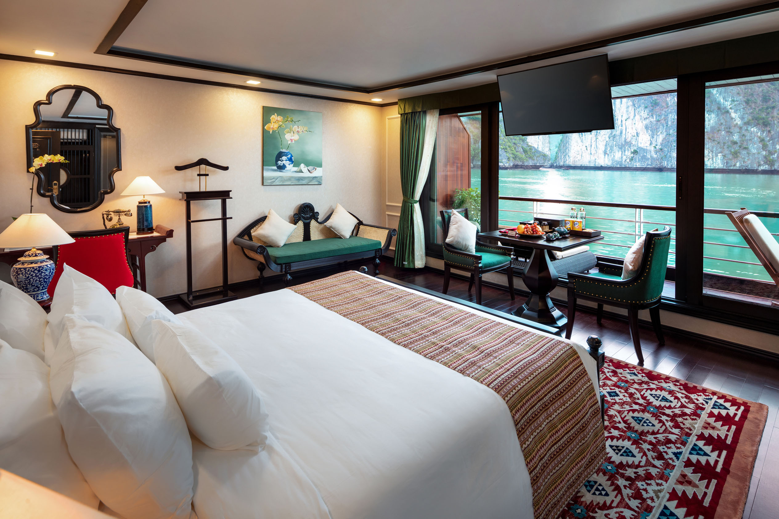 Luxury hotel room overlooking Halong Bay with modern decor and seating area.