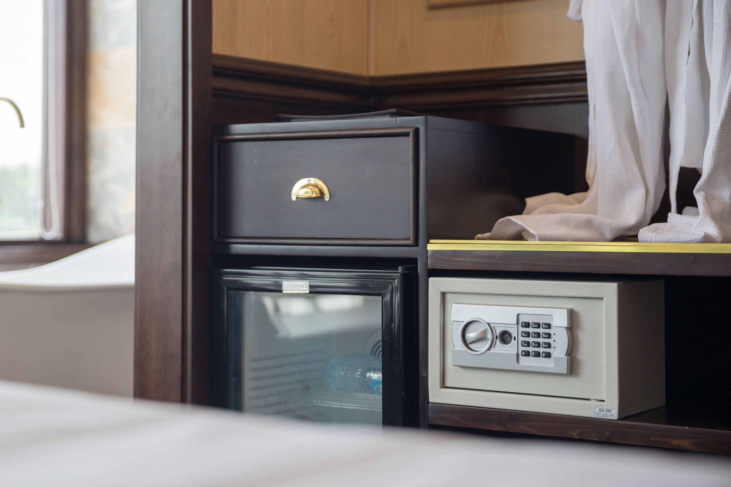 Safe hotel room with minibar, safe box, and wardrobe for a comfortable stay in Vietnam.