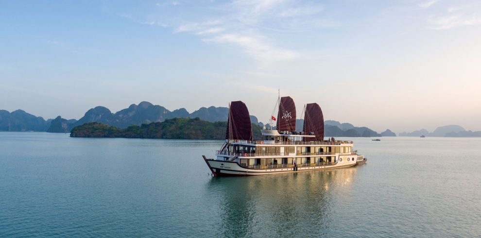 Luxury cruise boat sailing in Ha Long Bay, Vietnam, scenic limestone islands and emerald waters, eco-friendly tourism.