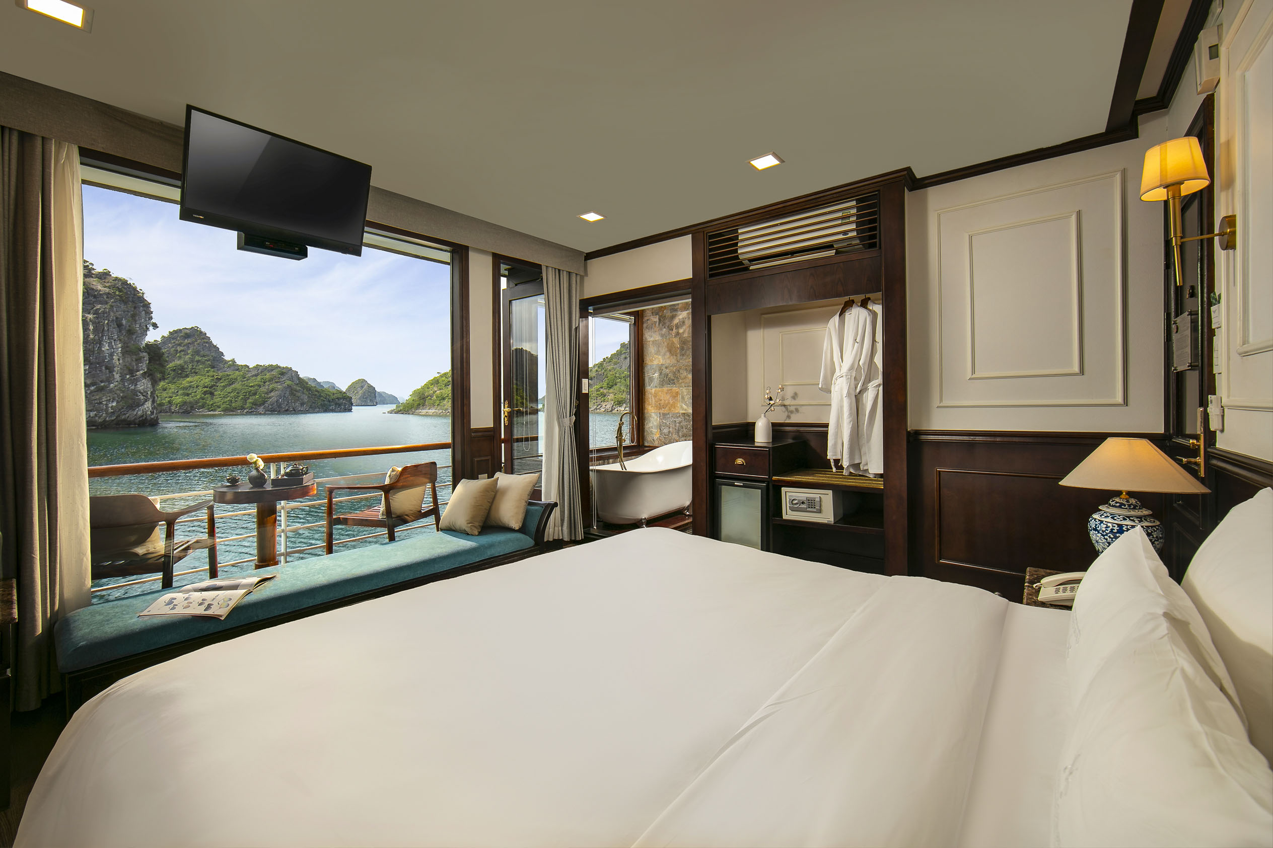 Breathtaking seaside hotel room with balcony overlooking limestone islands in Halong Bay.
