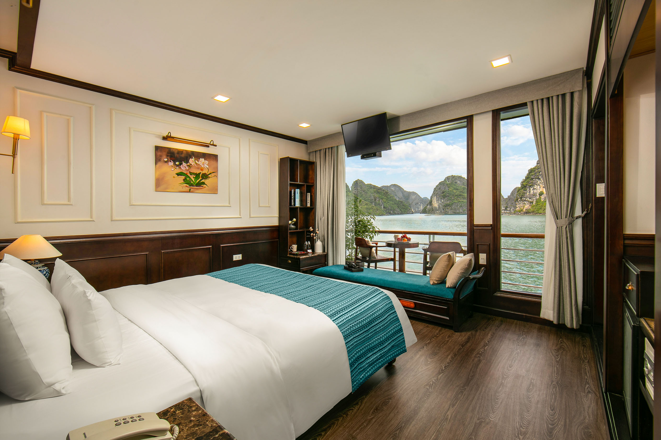 Panoramic view of luxurious hotel room overlooking limestone karsts and tranquil water in Ha Long Bay, Vietnam.