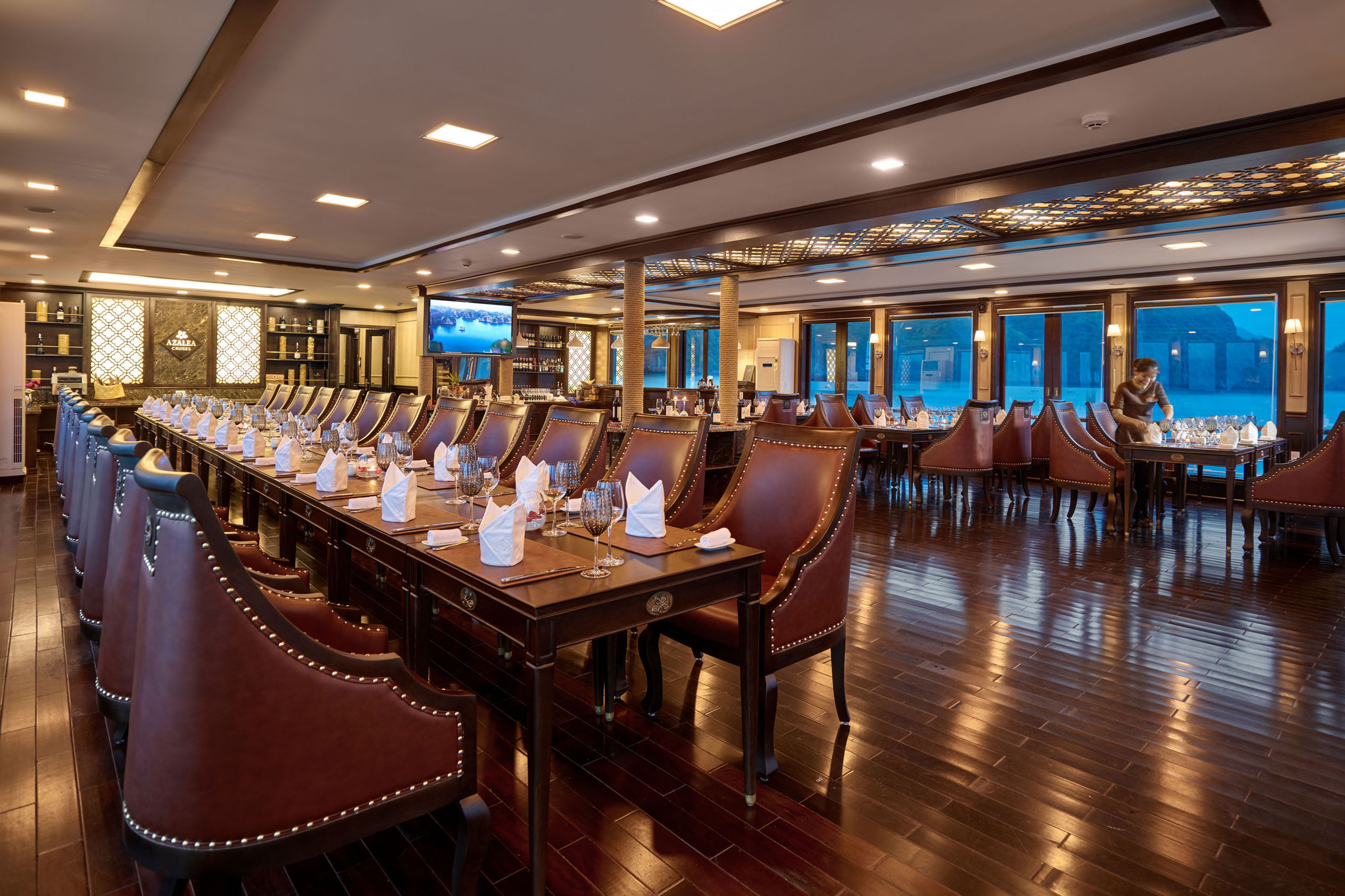 Luxurious cruise restaurant with elegant dining setup and panoramic water views for travelers.