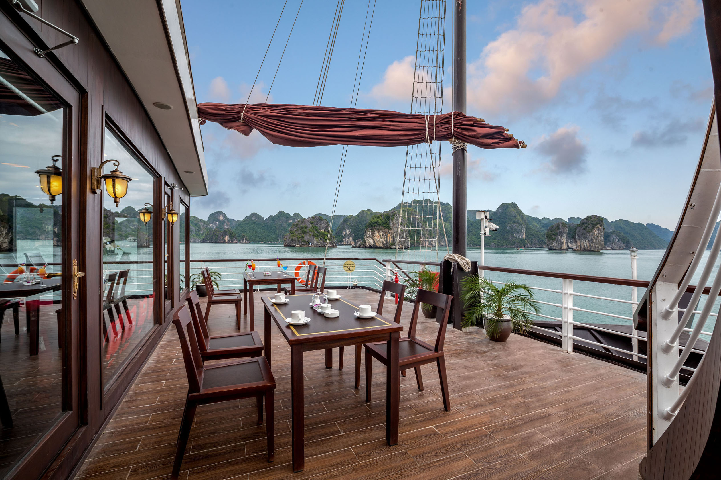 Elegant cruise ship deck overlooking limestone islands in Halong Bay, Vietnam, perfect for luxury travel and sightseeing.