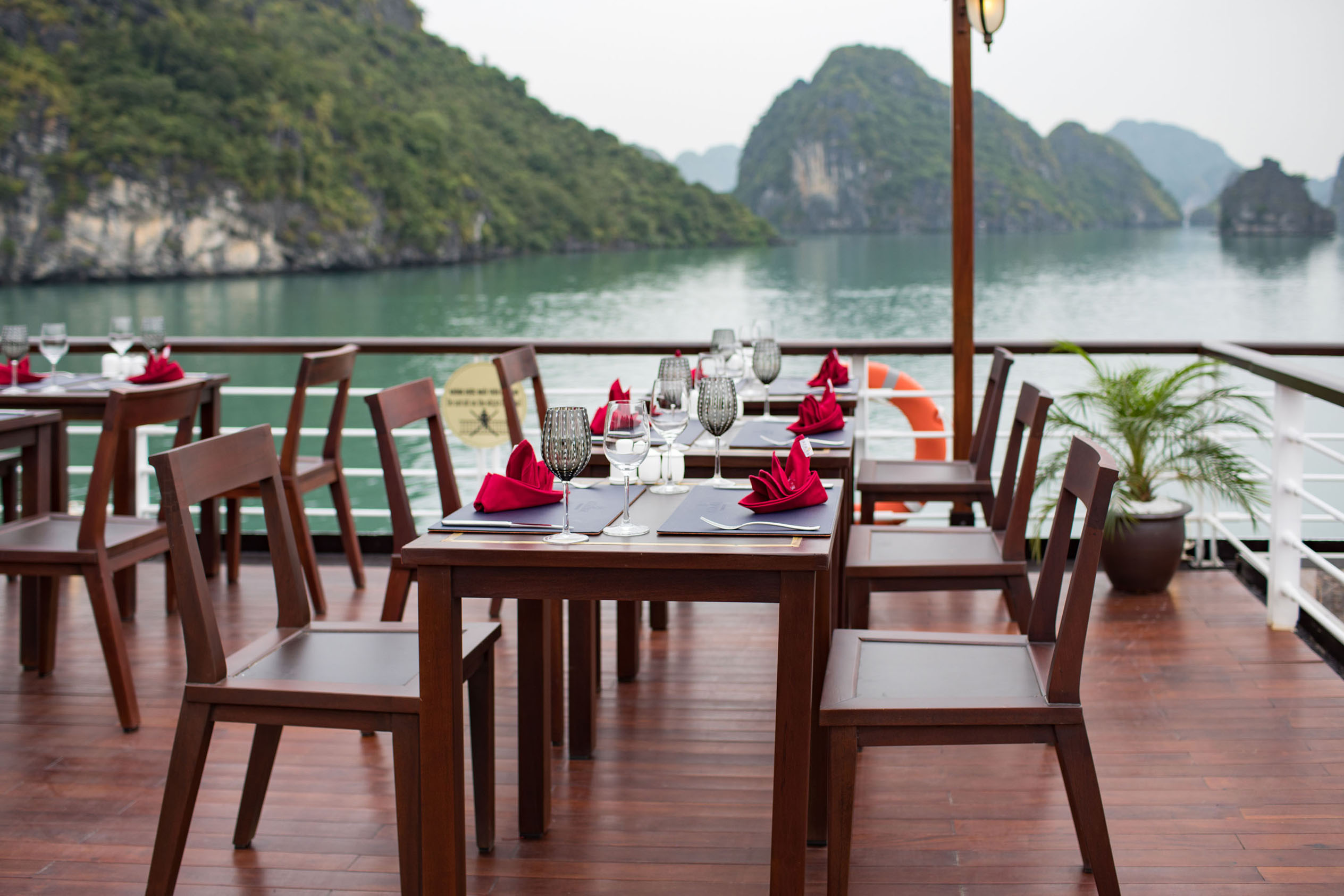 Luxurious boat dining setup with scenic gulf view and elegant table arrangements.