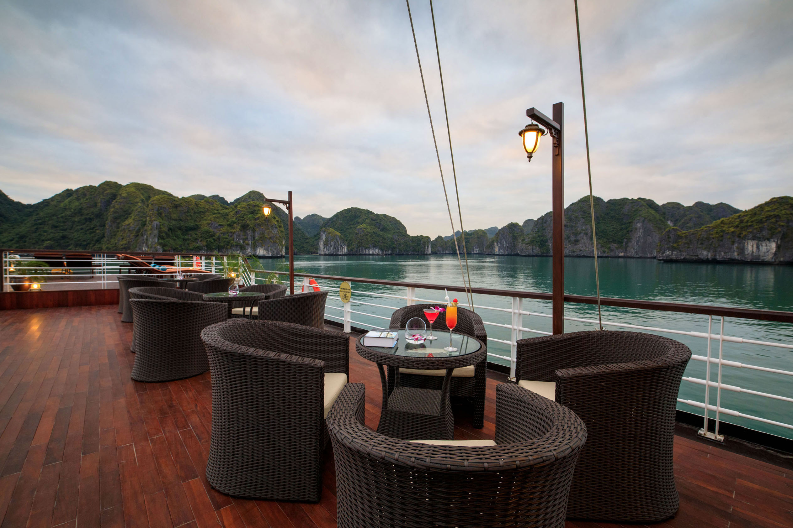 Relaxing outdoor cruise deck with scenic mountains and water view, perfect for tropical vacations.