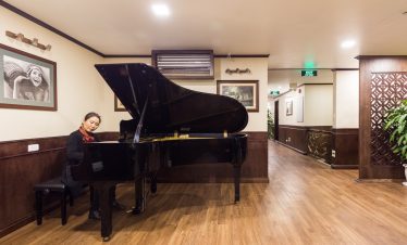 Relaxing scene on a luxurious cruise in Halong Bay with a pianist playing soothing music.
