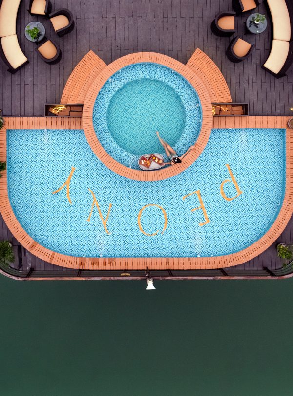 Aerial view of a luxurious swimming pool on a cruise in Halong Bay, with surrounding deck chairs and.