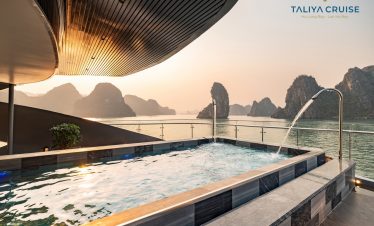 Stunning Halong Bay cruise balcony scene with sunset, limestone karsts, and tranquil waters.
