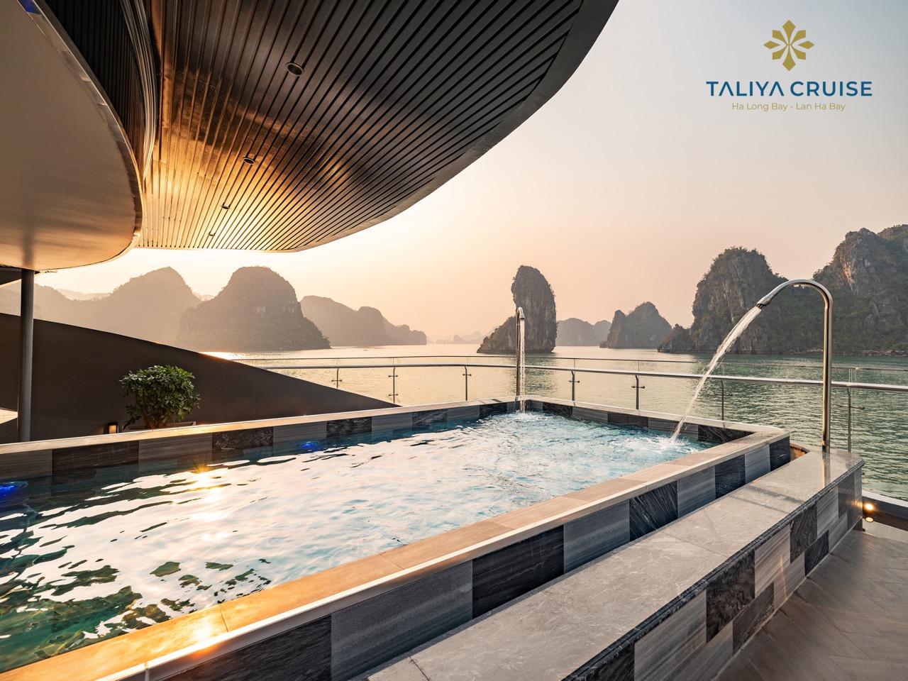 Stunning Halong Bay cruise balcony scene with sunset, limestone karsts, and tranquil waters.