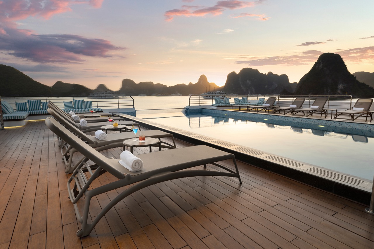Luxurious rooftop pool with stunning sunset view over limestone islands in Vietnam.
