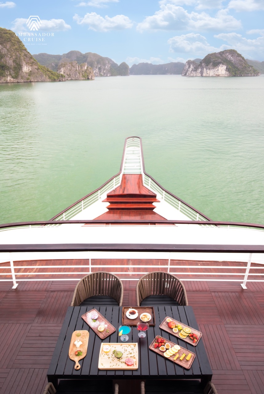 Stunning Halong Bay scenery from a luxury cruise balcony with calm waters and towering limestone isl.