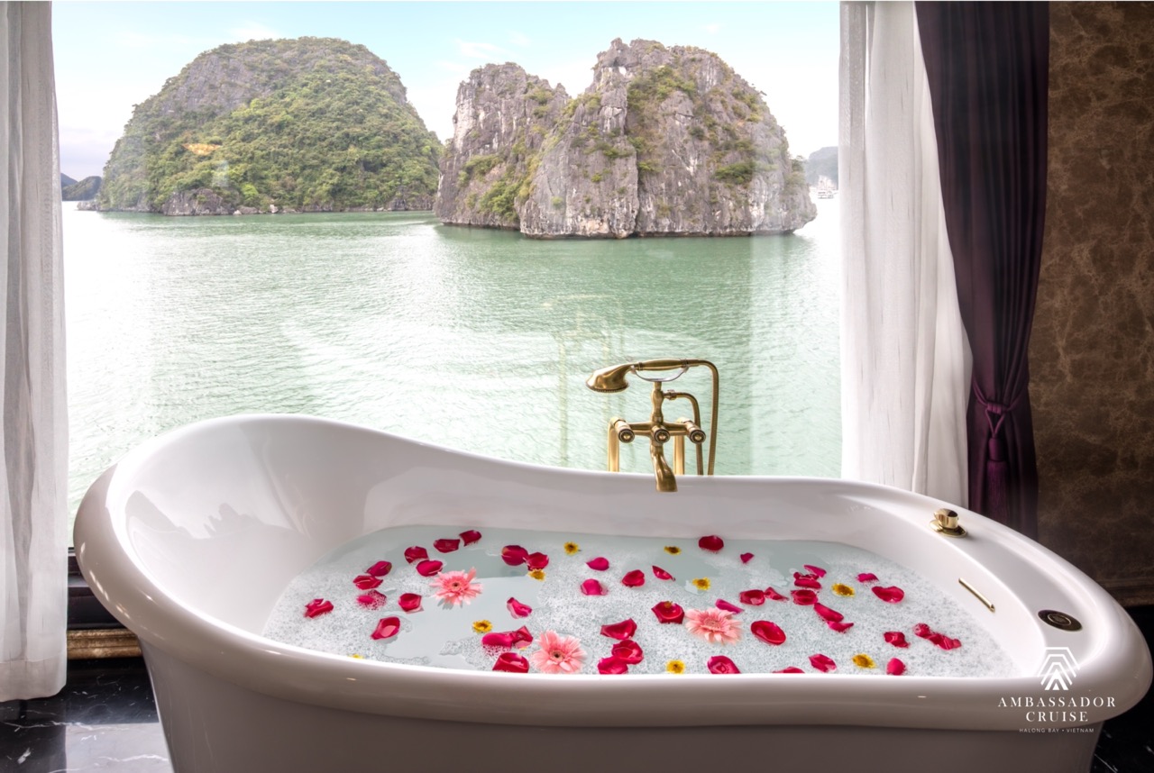 Stunning view of Halong Bay from a luxurious cruise balcony with floating islands in the background.