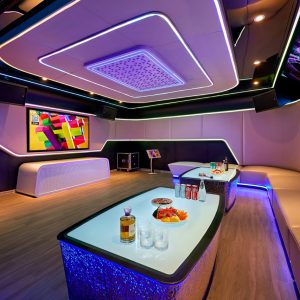 A modern luxury karaoke room with vibrant LED lighting and comfortable seating for entertainment.