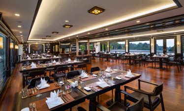 Elegant dining room on Peony Cruise in Halong Bay with panoramic views and luxurious ambiance.
