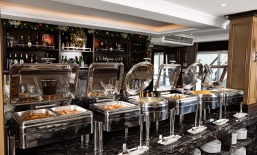Buffet station on a luxury Halong Bay cruise with diverse dishes and scenic backdrop.