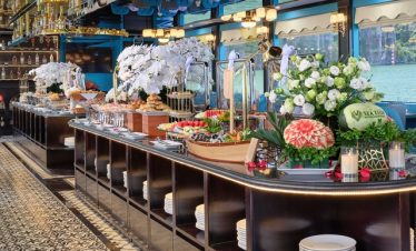 Elegant buffet setup on Sealion Halong Bay Day Cruise with floral decorations and scenic views.