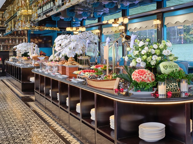 Elegant buffet setup on Sealion Halong Bay Day Cruise with floral decorations and scenic views.