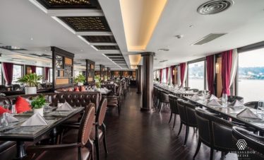 Elegant cruise balcony overlooking Halong Bay with calm waters and scenic karst formations.