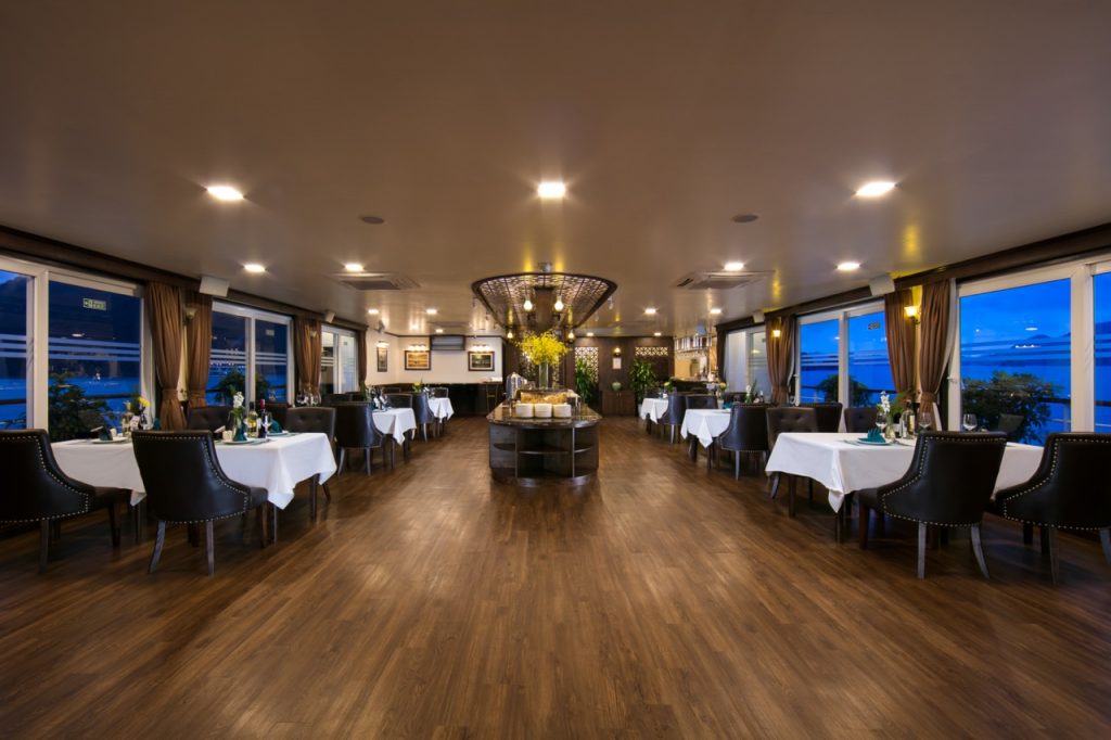 Luxurious cruise dining room with panoramic views of Halong Bay, perfect for a memorable 2D1N experi.