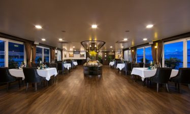 Luxurious cruise dining room with panoramic views of Halong Bay, perfect for a memorable 2D1N experi.