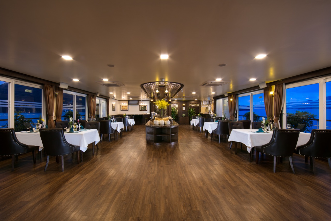Luxurious cruise dining room with panoramic views of Halong Bay, perfect for a memorable 2D1N experi.