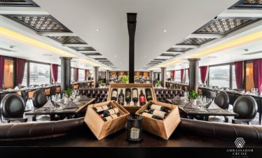 Elegant cruise lounge with panoramic windows and stylish decor in Halong Bay.