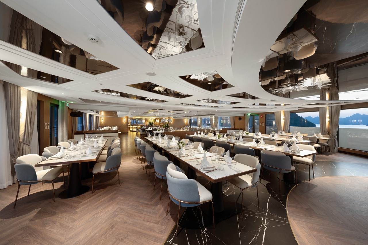 Luxurious waterfront banquet hall with elegant dining setup and panoramic sea views.