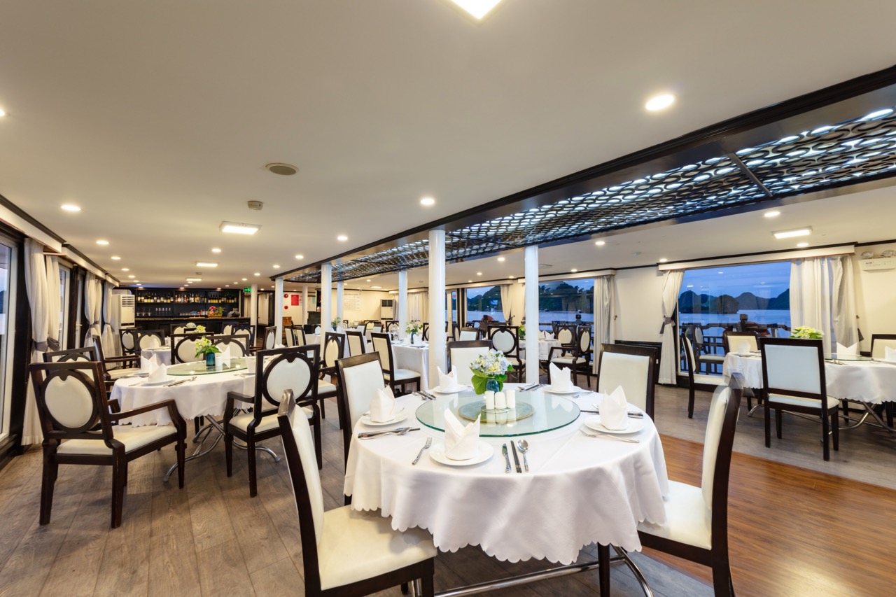 Luxurious yacht restaurant interior with elegant dining setup and scenic waterfront views.