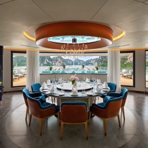 Luxury waterfront dining room with elegant table setting and scenic ocean view.