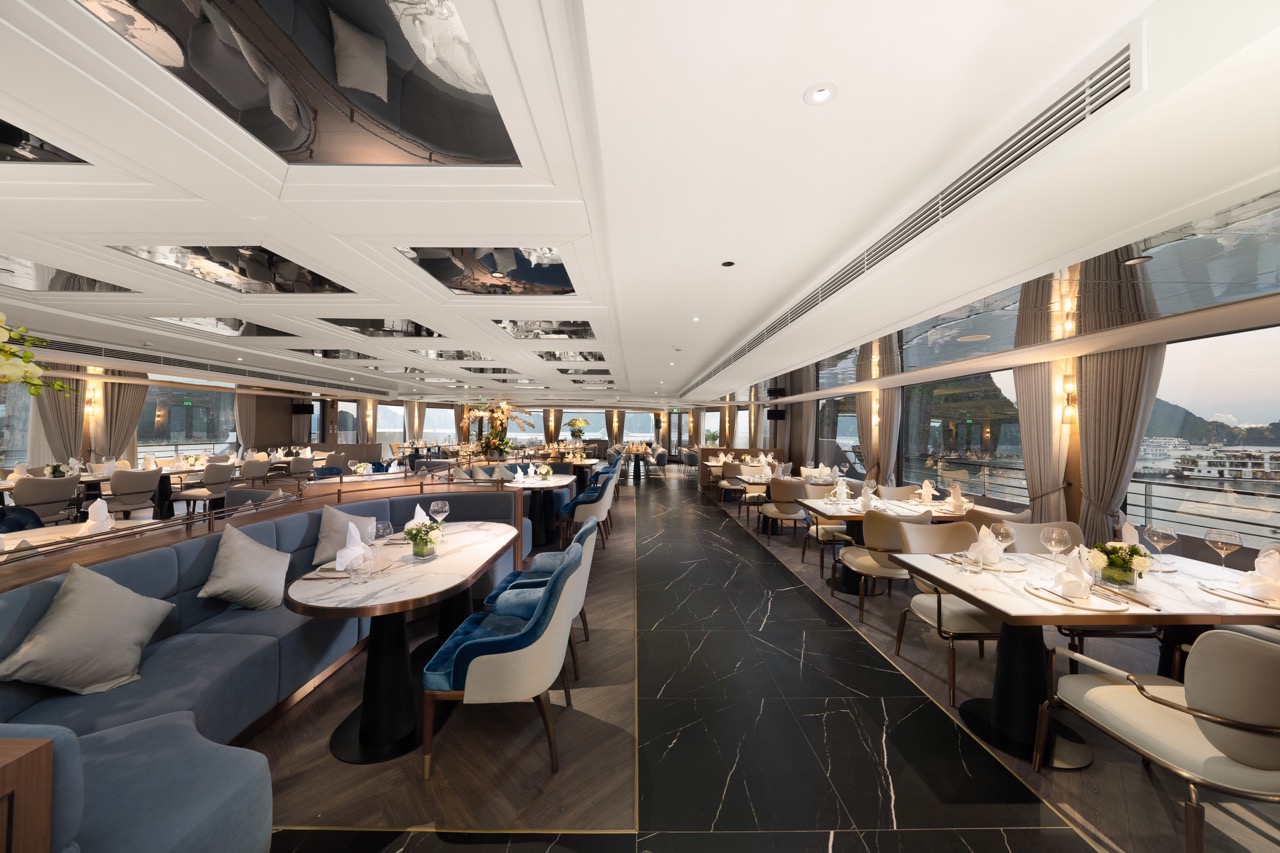 Luxurious yacht dining room with elegant seating and panoramic waterfront views.