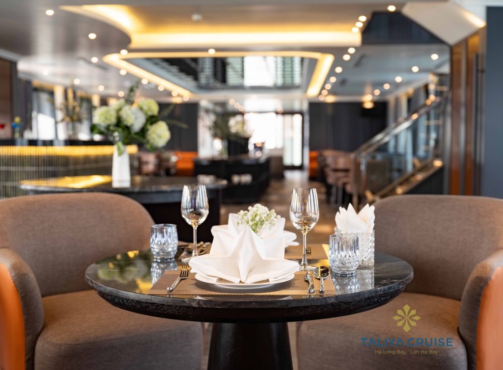 Elegant dining setup on Halong Bay cruise balcony with scenic views.