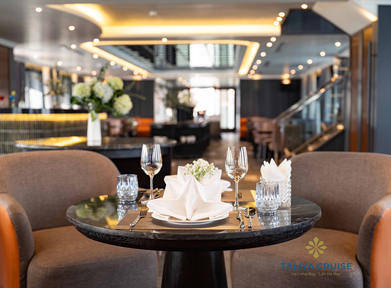 Elegant dining setup on Halong Bay cruise balcony with scenic views.