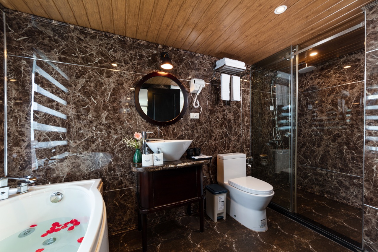 Luxurious marble bathroom with bathtub, modern fixtures, and walk-in shower at ViettrendTour.