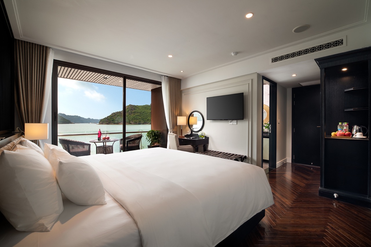 Luxurious hotel bedroom with sea view, balcony, modern decor, and comfortable king-sized bed.
