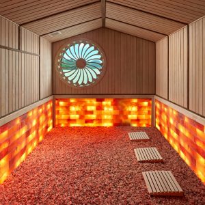Salt room therapy spa with Himalayan salt bricks and wooden decor for relaxation and wellness.