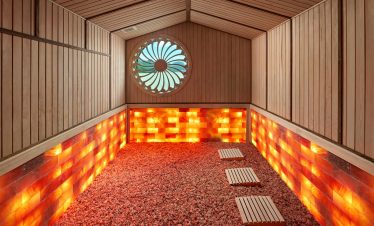 Salt room therapy spa with Himalayan salt bricks and wooden decor for relaxation and wellness.