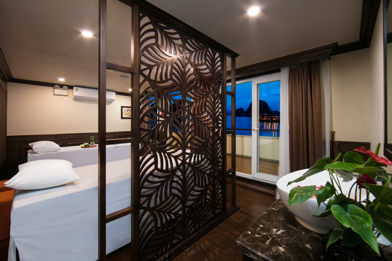 Beautiful cruise balcony view of Halong Bay with serene waters and sunset sky.
