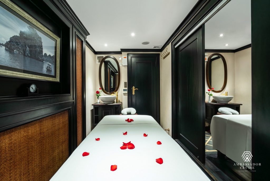 Luxurious cruise cabin with rose petals, elegant decor, and relaxing ambiance in Halong Bay.