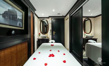 Luxurious cruise cabin with rose petals, elegant decor, and relaxing ambiance in Halong Bay.