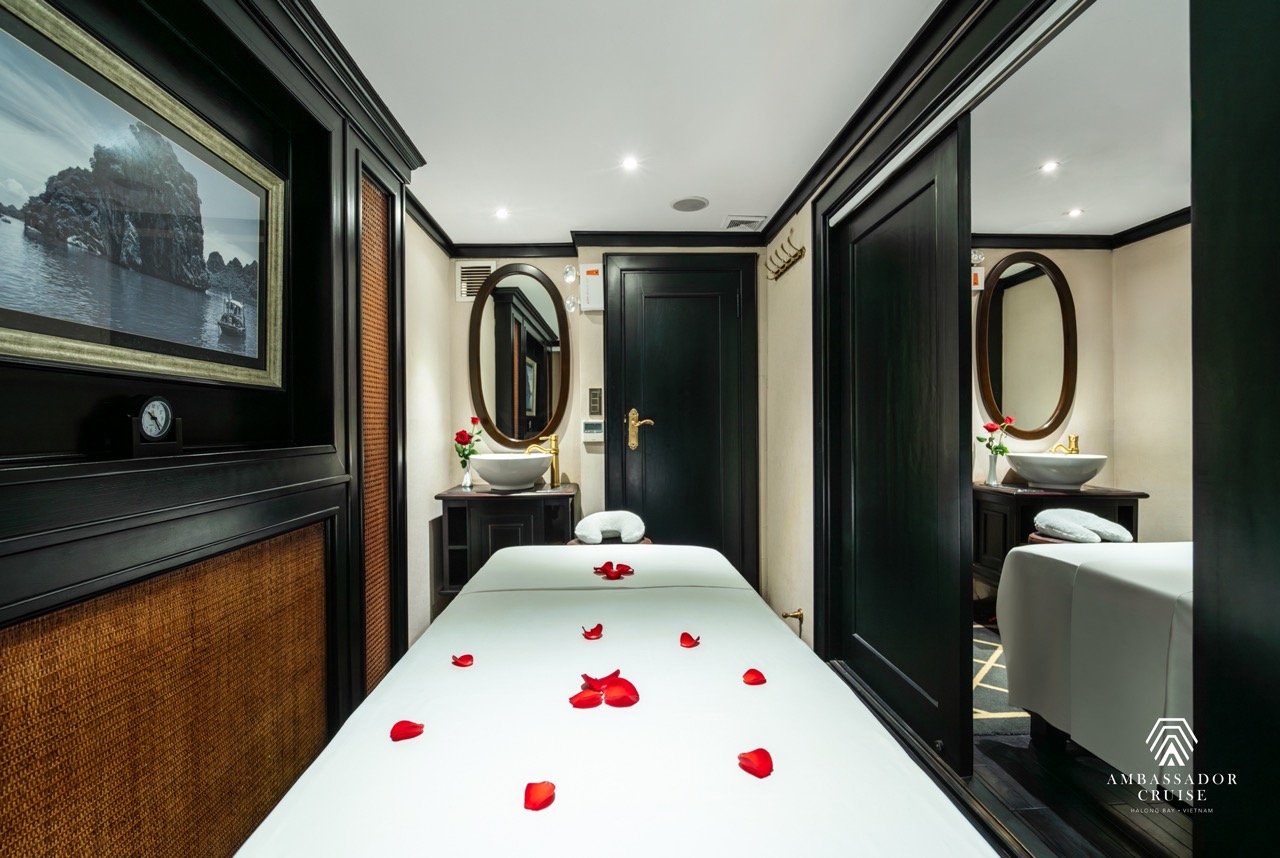 Luxurious cruise cabin with rose petals, elegant decor, and relaxing ambiance in Halong Bay.