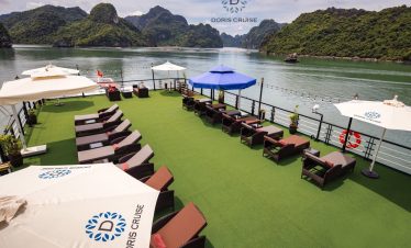 Relaxing on the luxurious cruise deck with stunning views of Halong Bay's limestone karsts.
