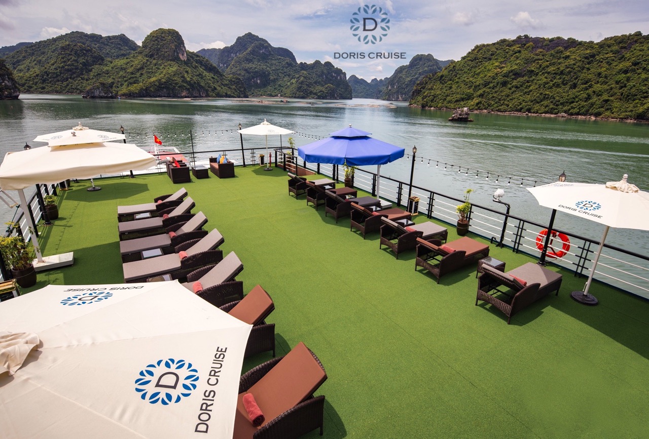 Relaxing on the luxurious cruise deck with stunning views of Halong Bay's limestone karsts.
