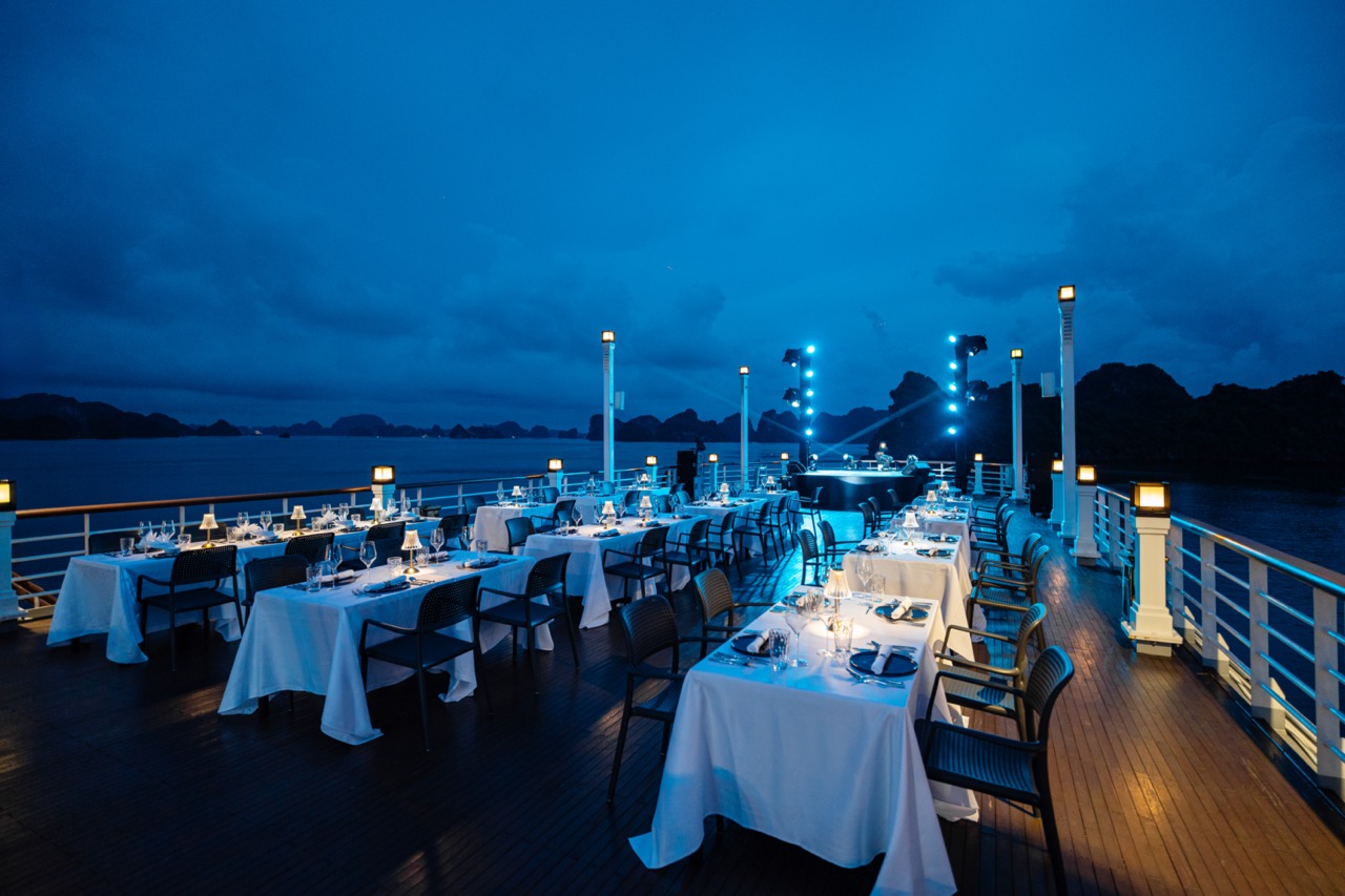 Elegant cruise balcony dining experience on Halong Bay at sunset, perfect for romantic travel and sc.